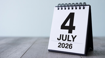 Minimalist standing desk calendar featuring bold black 4 July 2026 on white page, spiral bound, soft shadow, light gray wood surface, modern clean aesthetic, copy space.