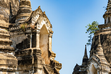 Weathered stone stupas and temple towers rising against clear blue sky