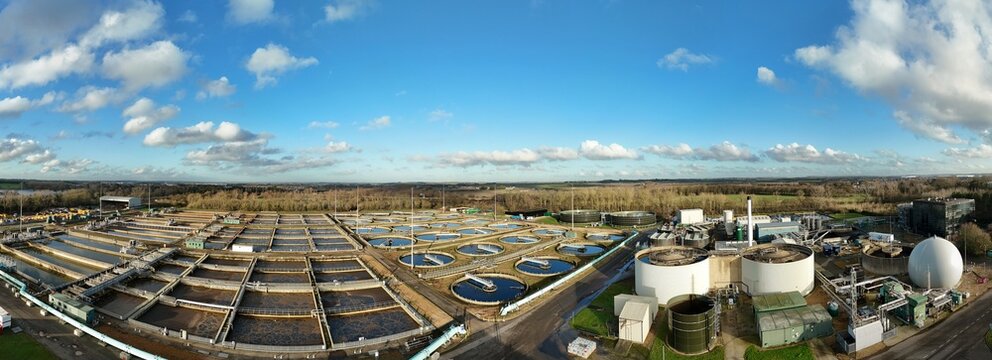 Aerial view of the facility's geometric shapes contrast against the natural landscape, creating a stark juxtaposition of industry and nature, Milton Keynes, England, United Kingdom.