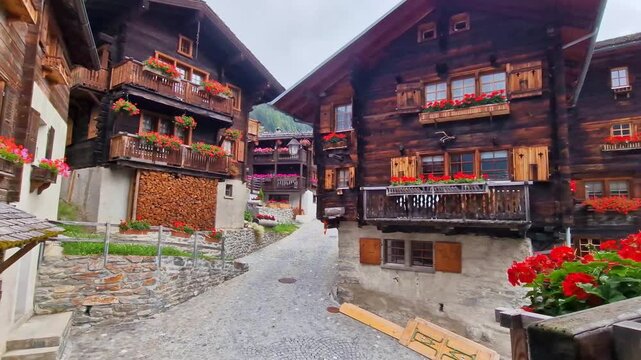 Authentic Swiss villages -  Grimentz with traditional dark wood houses and geranium flowers decoration.  Valais, Switzerland 