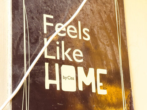 Feels Like Home sign by Ciss, featuring bold typography and a warm color palette, creating a welcoming atmosphere with copy space for design purposes