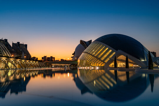 Futuristic architecture reflecting in calm water during blue hour in valencia, spain