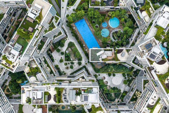 Aerial view of a unique residential complex with swimming pools and lush greenery, showing a harmonious blend of architecture and nature, Interlace Condominium, Telok Blangah, Singapore.