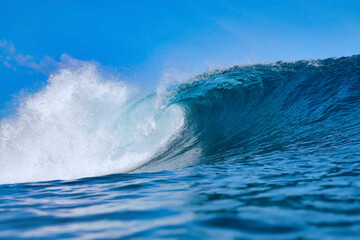 Blue Ocean Wave Curling Toward Shore, Giant Turquoise Barrel Captured MidBreak, Spray Arcing, Sunlight