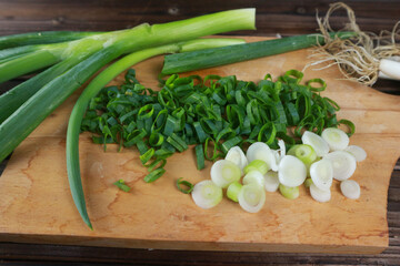 fresh cut leek on chopping board on wooden table
