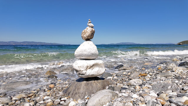 Silhouette of balanced zen-stones on the ocean beach.