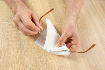 mature male hands carefully cleans glasses with thin metal frame, emphasizing vision health, eyewear maintenance and personal hygiene, visual clarity, Daily Routine