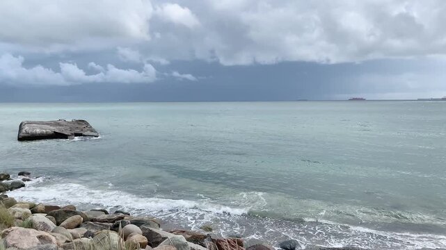calm sea with approaching storm clouds at skagen coast; video of a calm sea along the skagen coastline in denmark as dramatic storm clouds gather on the horizon