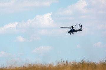 British army AH-64E Boeing Apache attack helicopter flying over Salisbury plain training area on a slight cloudy day