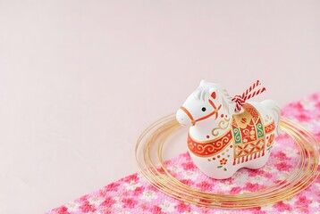 Decorative horse figurine on pink background isolated on white background