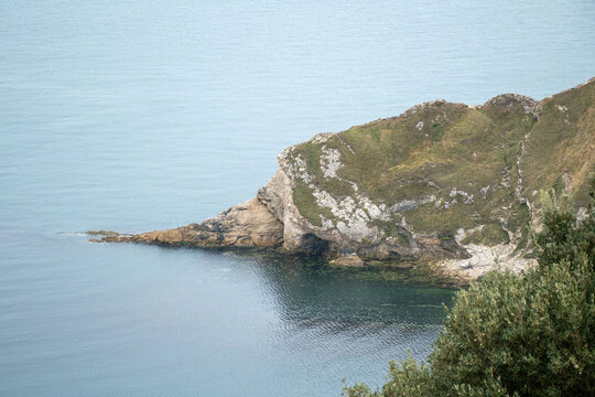 Scenic view of Lulworth Cove on the Jurassic Coast, showcasing natural beauty, rugged cliffs, and tranquil waters, ideal for relaxation and tourism.