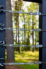 Tensioners keep metal cables taut