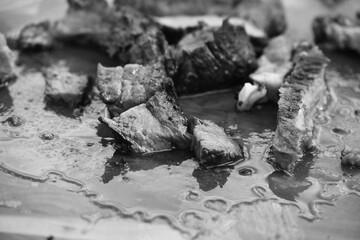 Grilled steak pieces cut up in black and white on cutting board closeup.
