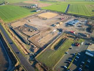 Aerial view of deep excavations seen adjacent to an established industrial zone in the UK. A staff car park for an existing company is at the bottom right.