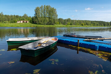 Plastic rowing boats at the river pier are ready for water trips, waiting for tourists.