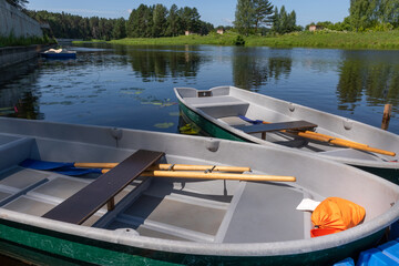 Plastic rowing boats at the river pier are ready for water trips, waiting for tourists.