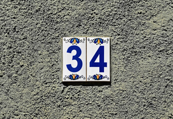 Street sign number 34 on a gray wall