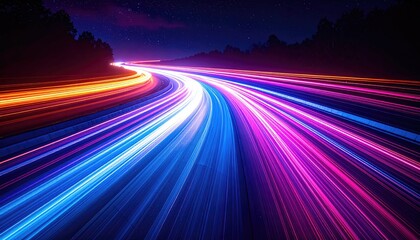 Long exposure captures vibrant light trails of speeding vehicles along a winding, dark highway at night