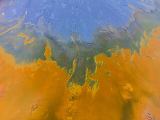 Beautiful aerial pattern of colorful water and mud, shot with a drone located at Geamana, Romania, a formerly village that was covered with toxic waste from a mining operation nearby