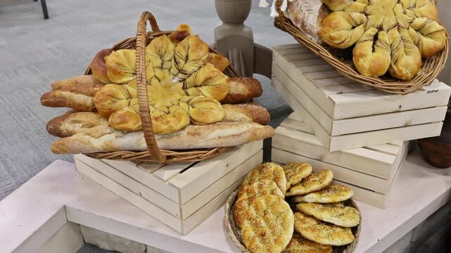 Artisan breads in different shapes are arranged in decorative baskets at local bakery.