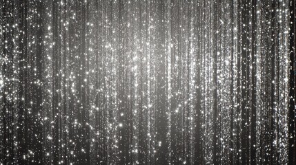 Light reflects off vertical silver strands giving a sparkling effect in a dim setting during a celebration event