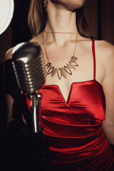 Chanteuse rétro en robe rouge avec son microphone rétro et vintage