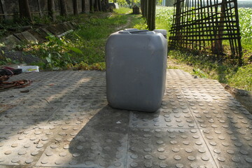 Grey Plastic Jerry Can on a Textured Outdoor Path