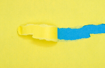 torn yellow paper on blue background