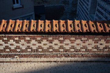 Mur de brique avec faitage en tuiles