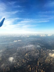 Aerial Cityscape From Airplane Window, Soft Sunlight Bathing Highrise Skyline Beside Wingtip, Scattered Clouds Drifting Toward Distant Horizon Mood Calm And Reflective, Suggests Business Traveler En