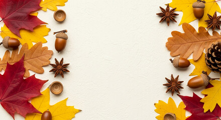 Autumnal arrangement featuring red, yellow, brown leaves, acorns, pinecones, and star anise on a white background Large central free space ideal for text or logo