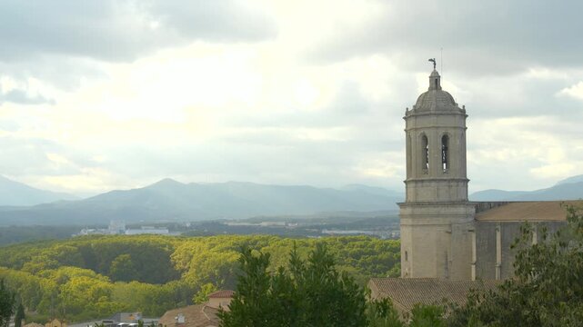 Cloudy Sky and Warm Light Over Girona City with Cathedral and Mountains Creating Peaceful European Atmosphere