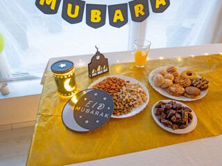Eid Mubarak table with Ramadan sweets, dates, nuts and festive decor