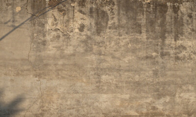 weathered concrete wall features textured surface muted earthy tones warm golden light casting long shadows