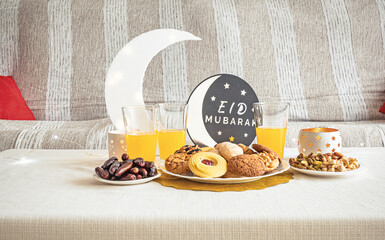 Eid Mubarak table with Ramadan sweets, dates, nuts and festive decor