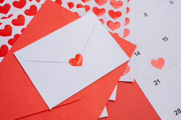 Heart sticker on calendar and love letter. Valentine's Day date planning.