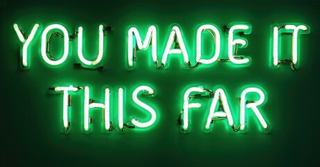 Bright green neon sign displays positive message. Text reads You Made It This Far against dark background. Simple, encouraging design.