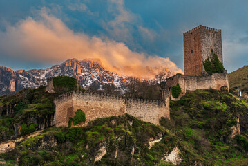 Historic Yedra Castle overlooking snow capped mountains at sunset in Cazorla, Andalusia