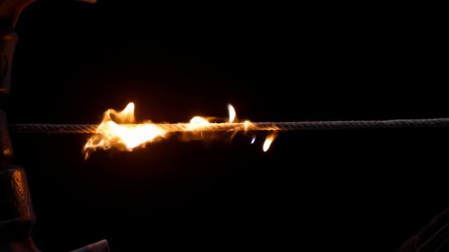 Dramatic slowmotion of bowstring being cut in intense fiery sequence