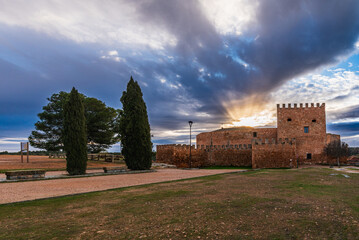 Pe&ntilde;arroya Castle bathed in the warm light of sunrise, Argamasilla de Alba, Ciudad Real, Spain. Majestic historic fortress with dramatic sky.