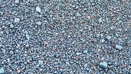 A black beach made of sea-rolled particles of pyroclastic material on a volcanic, Sulawesi Sea. Indonesia