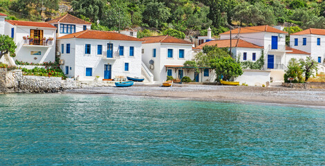 houses with white facades and blue shutters on the edge of a beautiful sea  in a greek village in Peloponnese