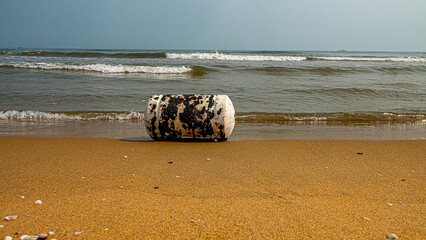 Oil pollution of sea, coast. Floating objects (flotsam, trawl float) are covered with fuel oil and bring toxin to other parts of sea, secondary pollution. Sandy beach attacked by fuel. South China Sea