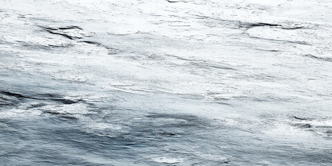 Winter ice and snow surface creating a rugged texture and abstract background with cold, frozen pattern