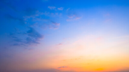 Fototapeta premium Beautiful sunset sky background with soft orange and blue gradient clouds at twilight