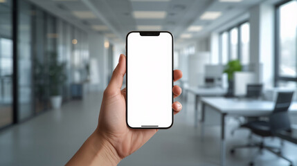 The Connected Workspace: A hand holds a sleek smartphone with a blank screen against the backdrop of a modern office space, ready for your message. 