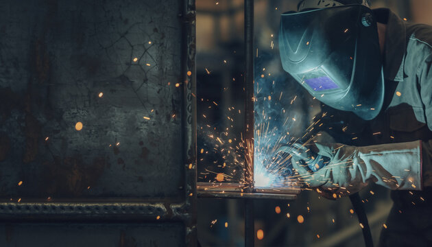 Industrial Welder Working with Protective Mask and Gloves in Factory Workshop - Powered by Adobe