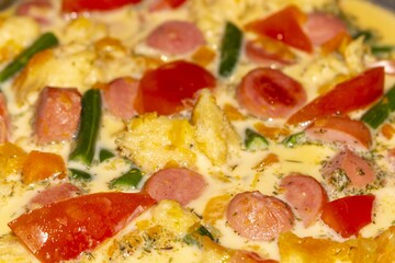 Delicious homemade pizza with sausage tomatoes and green pepper on a light background