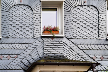 Architectural detail of the traditional slate facade, geometric pattern, gutter and wood elements, handcrafted surface