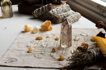A top view image of a beautiful crystal healing grid with garden quarts and citrine crystal mixed with white sage smudge sticks and roses. 